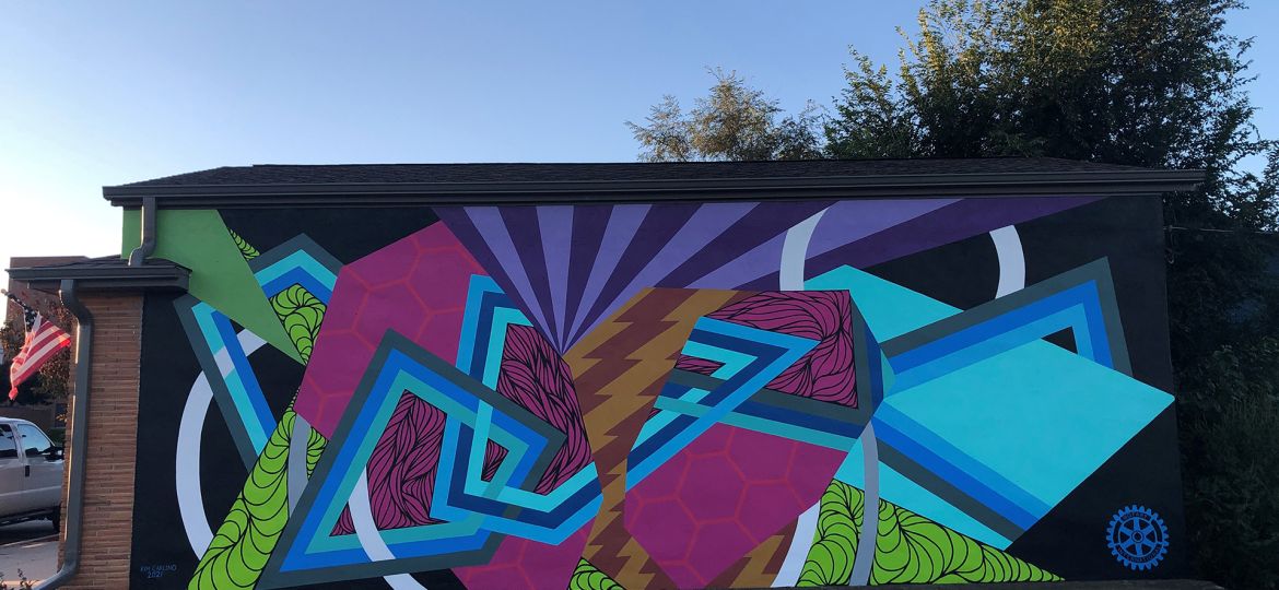 The Rotary Mural with large interlocking geometric shapes in purple, blue, bright pink, and lime green.