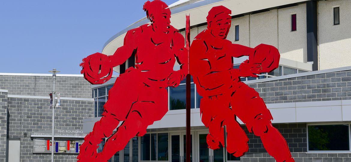 Drills sculpture closeup, a large bright red sculpture of two people playing basketball