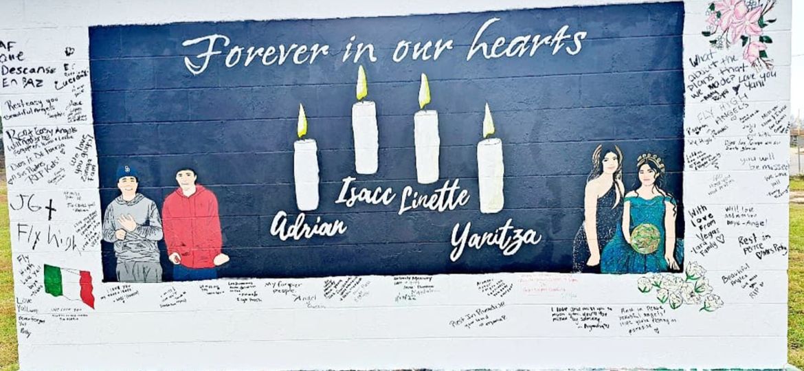 The graffiti wall painted with the words "Forever in our hearts, Adrian, Isacc, Linette, Yanitza" with painted candles and portraits of them, surrounded by messages from community and family members